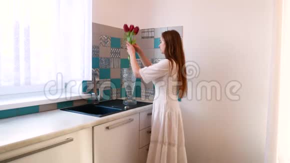 一个穿白色衣服的女孩把花放在花瓶里视频的预览图