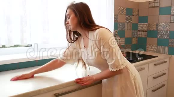 穿白色连衣裙的女孩在厨房打扫卫生视频的预览图