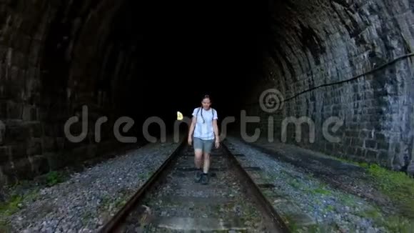 带着辫子和短裤的女孩沿着一条古老的石头铁路隧道散步视频的预览图