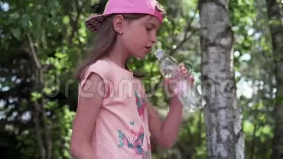口渴的女孩在公园里喝水视频的预览图