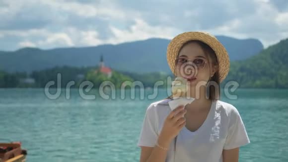女游客正在布莱德湖沿岸的度假胜地吃冰淇淋视频的预览图