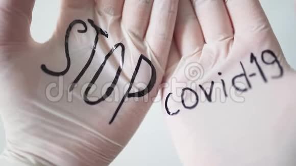 白色医用手套上的黑色铭文停止covid19冠状病毒大流行期间的健康和医学特写视频的预览图