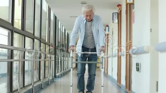 一位亚洲老人在用步行器走路回家视频的预览图