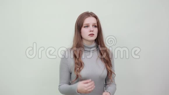 年轻漂亮的红发女子穿着灰色毛衣肩上有头发视频的预览图