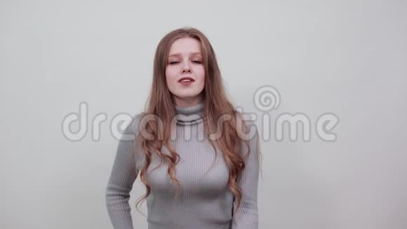一位身穿灰色毛衣的红发美女看起来很时髦还能做一个空中亲吻视频的预览图