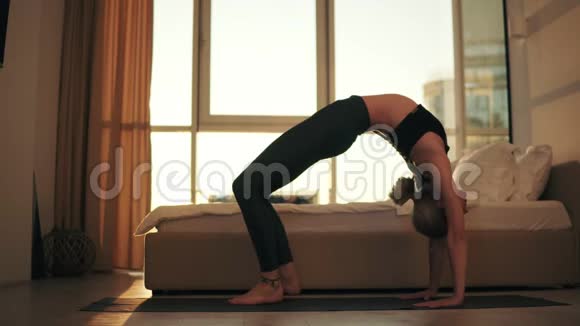 在家客厅里一位年轻女子在做瑜伽体式右腿朝上在窗前表演视频的预览图