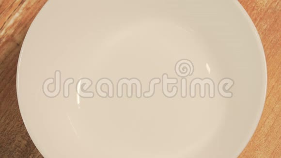 女人手把切成片的牛油果放在一个白色的盘子里烹饪纯素沙拉特写俯视图视频的预览图