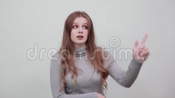 穿灰色毛衣的年轻红发女郎想出了一个新主意视频的预览图