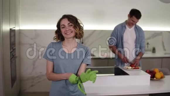 坚定的妻子准备开始打扫家庭的肖像戴上绿色手套对着镜头微笑关于视频的预览图