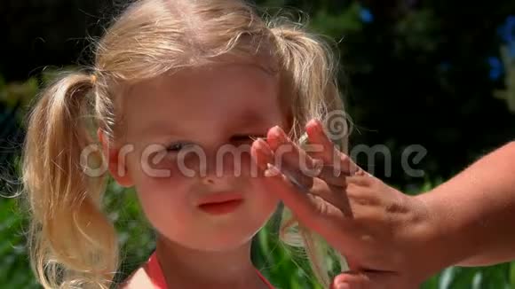 手在女孩脸上涂保护霜视频的预览图