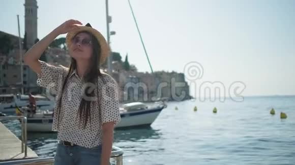克罗地亚Rovinj海滨戴夏帽的年轻微笑女士视频的预览图