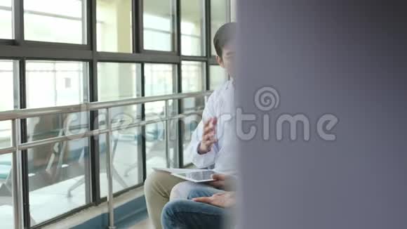 一位亚洲医生在医院走廊上和老人说话视频的预览图