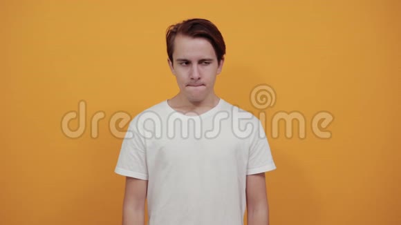 一个穿白色t恤戴黄色背景的男人用食指指着脸视频的预览图