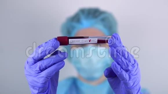 医生一名妇女拿着一个试管手里拿着一个阳性的covid19冠状病毒测试看着它视频的预览图