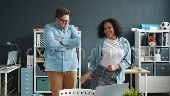 快乐的同事男人和女人在办公室跳舞一起在室内玩得开心视频的预览图