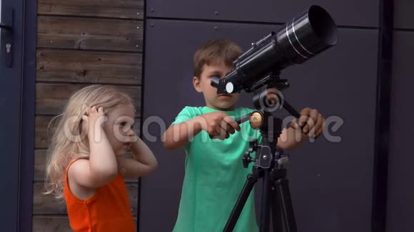 小女孩和一个可爱的男孩正在用望远镜探索天空视频的预览图