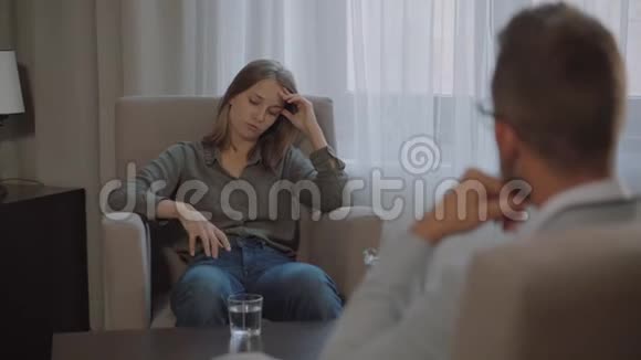 女人在谈论坐在精神分析师办公室椅子上的问题视频的预览图