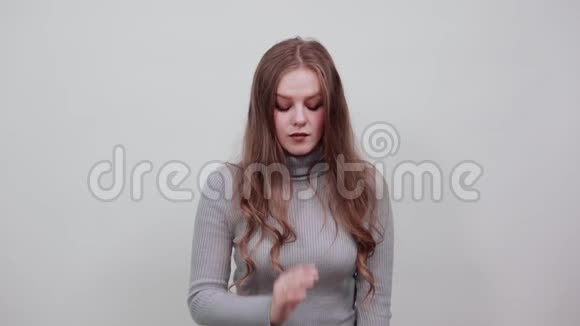穿灰色毛衣的红发女人造型时尚用手调整头发视频的预览图