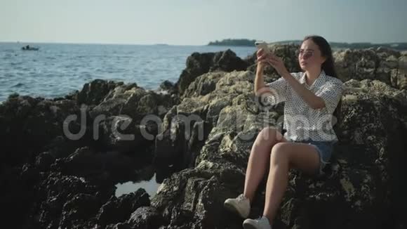 欣赏海景的女孩拍着海浪拍的手机视频的预览图