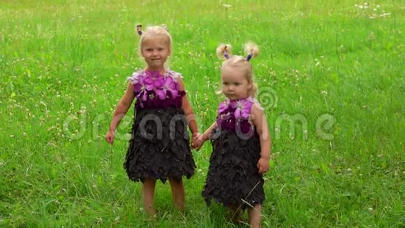两个小妹妹穿着由树叶和花朵组成的紫色梦幻裙视频的预览图