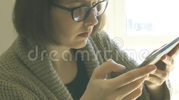 戴眼镜的白人女人用平板电脑视频的预览图