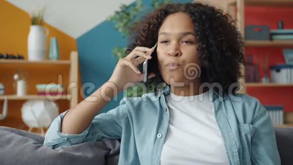 年轻的非裔美国妇女在家里用手机说话的动作缓慢视频的预览图