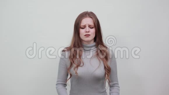 穿灰色毛衣的红发女子用手修剪头部头痛难忍视频的预览图