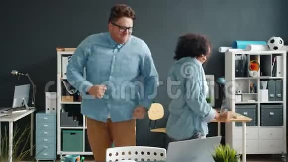 男女同事在办公室跳舞时动作缓慢男的正在摔倒视频的预览图