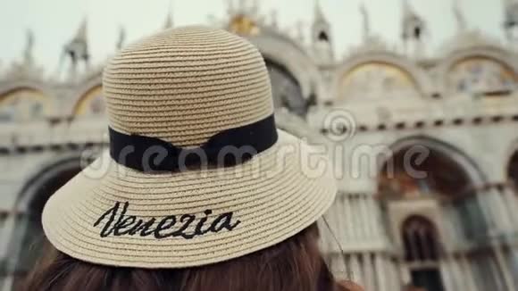 穿草帽的女孩站在圣马可广场看着巴西利卡圣马可视频的预览图