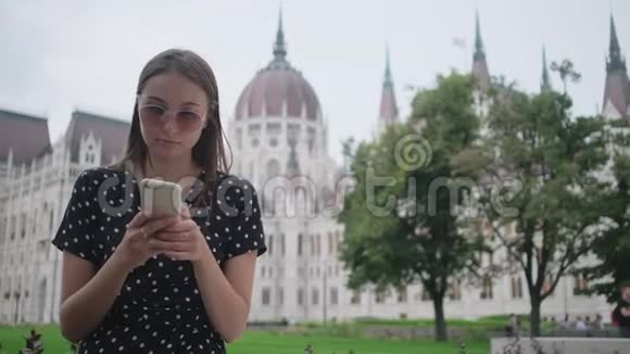 漂亮女孩在户外等朋友用手机匈牙利布达佩斯视频的预览图