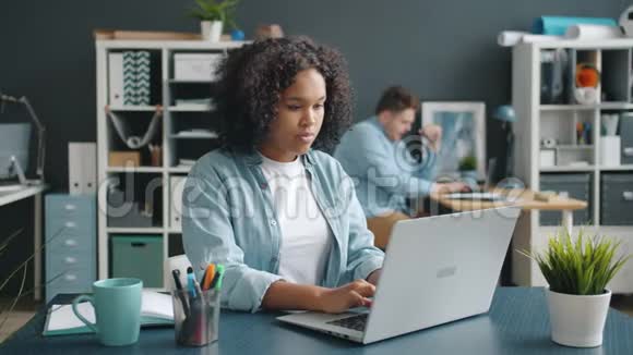 非裔美国人办公室工作人员使用现代笔记本电脑做笔记视频的预览图