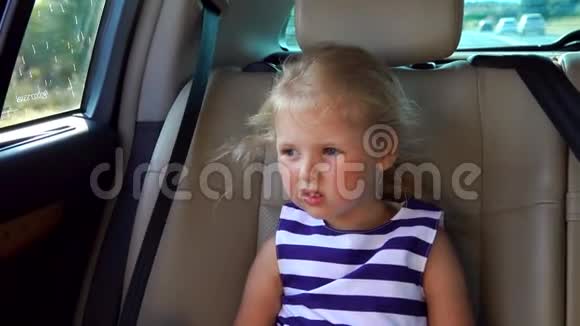 戴帽子的漂亮金发女孩正坐在车后座上视频的预览图
