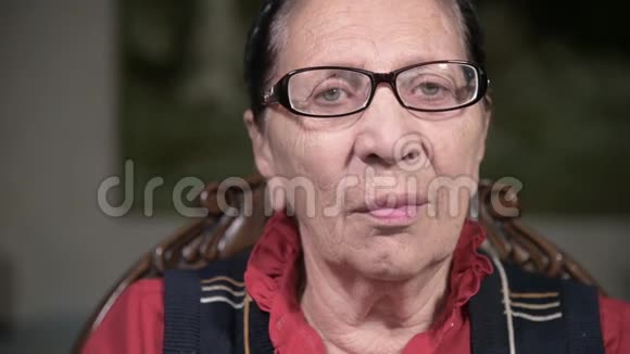 一个戴着眼镜的老年沉思的女人在室内坐着思考靠在手臂上的肖像老年妇女80岁视频的预览图