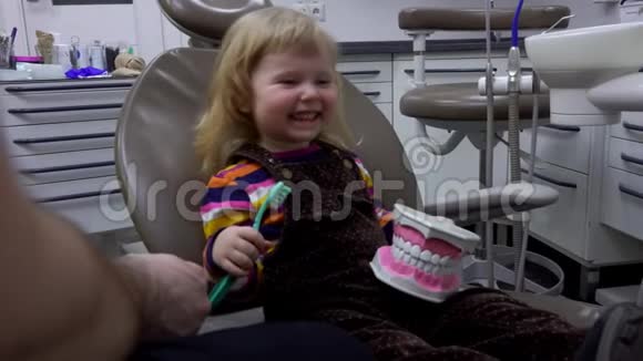 快乐的小女孩正在学习如何清洁她的牙齿在下巴模型视频的预览图