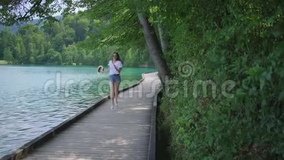女人在大自然的湖岸上奔跑旋转视频的预览图