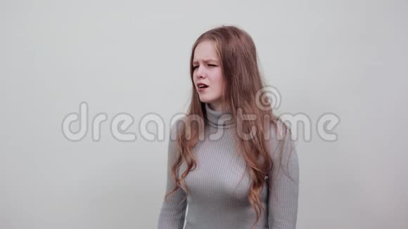 穿灰色毛衣的红发女子流露出悲愁烦恼的情绪视频的预览图