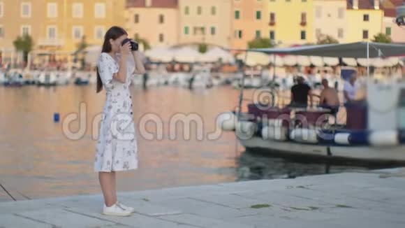 女游客正在拍摄克罗地亚罗文吉市的港口视频的预览图