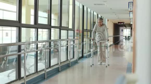 一位带着步行者在养老院散步的亚洲老妇人视频的预览图