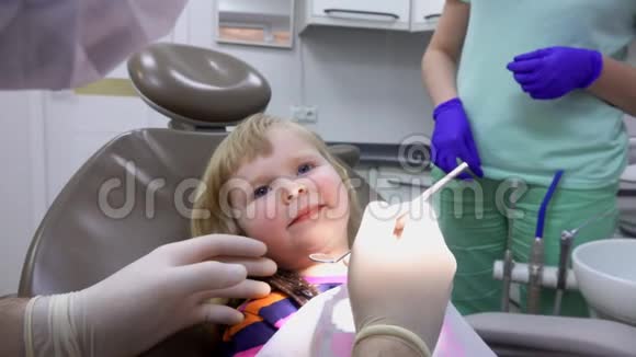 牙医检查一个小镜子的小女孩的牙齿视频的预览图