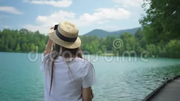 夏天女人正走在湖岸的小路上视频的预览图