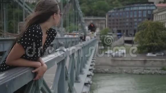 夏日在欧洲城市链桥上的年轻女子视频的预览图