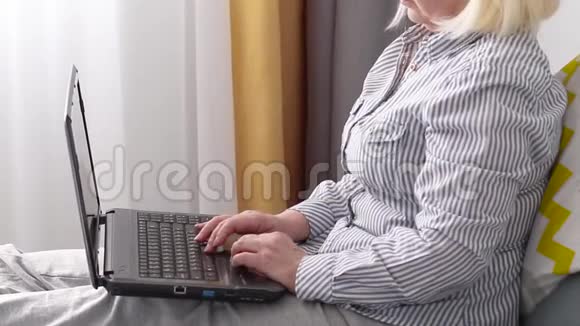 呆在家里冠状病毒的概念用笔记本电脑在床上合上女性的手视频的预览图