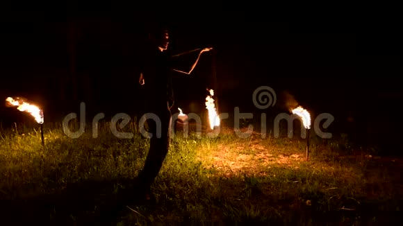 黑暗中缓慢的人转动着燃烧的球低调消防表演特写镜头视频的预览图