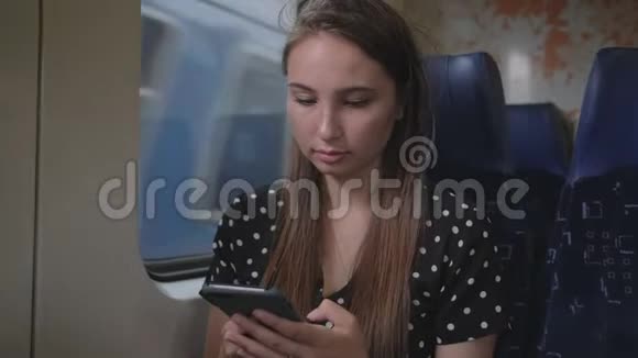 郊区火车的女乘客正在使用智能手机视频的预览图