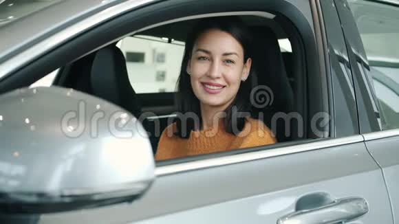 新车经销商内的女孩微笑着看着镜头的照片视频的预览图