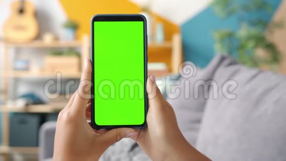 家庭女性手中的绿色屏幕模板智能手机特写镜头视频的预览图