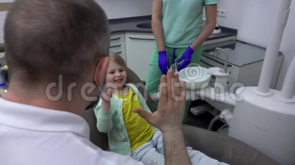 牙医给一个坐在椅子上的小女孩一个击掌视频的预览图