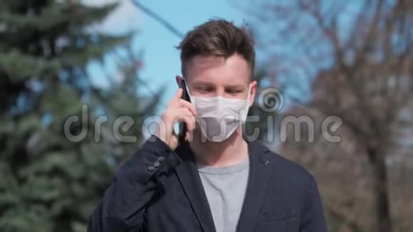 戴着医疗面具的人穿着夹克去打电话COVID19或冠状病毒2019概念慢动作4K视频的预览图