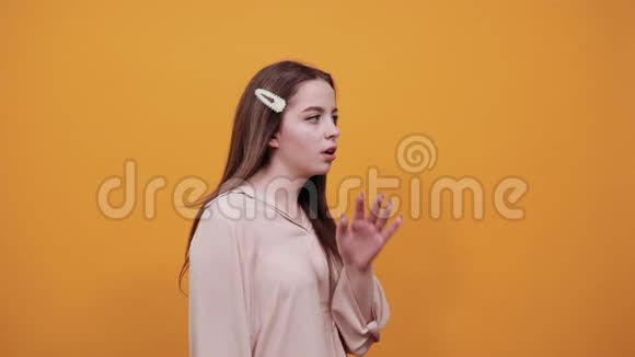 白人年轻女子侧着身子用手掌捂住嘴说话视频的预览图
