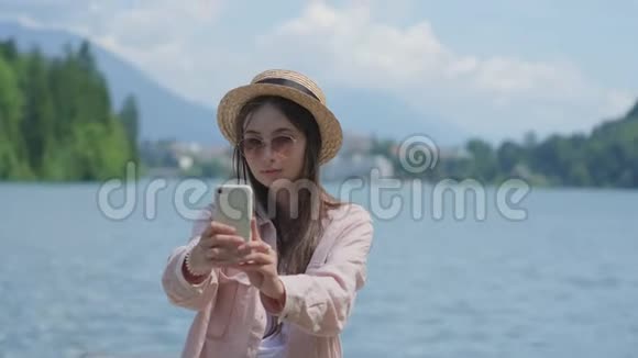 在斯洛文尼亚亚洲女人正在用手机拍摄自己的照片视频的预览图